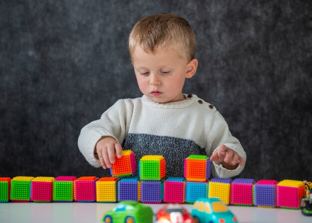 Zwei Jahre altes Baby, das mit Würfeln spielt