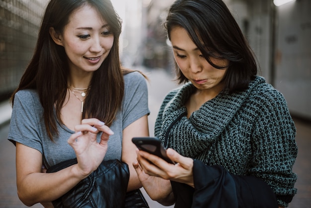 Zwei japanische Frauen herum in Tokio während des Tages. Einkaufen und Spaß haben