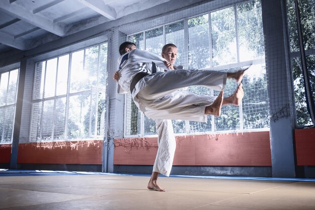 Zwei Judo-Kämpfer, die technische Fähigkeiten beim Üben von Kampfkünsten in einem Kampfclub zeigen. Die beiden passen Männer in Uniform. Kampf, Karate, Training, Kunst, Athlet, Wettkampfkonzept