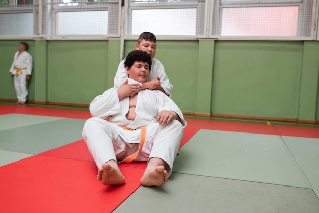 Zwei Judo-Kämpfer, die technische Fähigkeiten zeigen, während sie Kampfkunst in einem Kampfclub praktizieren Die beiden fitten Männer in Uniform kämpfen Karate-Trainingssportler-Wettkampfkonzept Selektiver Fokus