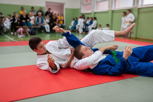 Zwei Judo-Kämpfer, die technische Fähigkeiten zeigen, während sie Kampfkunst in einem Kampfclub praktizieren Die beiden fitten Männer in Uniform kämpfen Karate-Trainingssportler-Wettkampfkonzept Selektiver Fokus