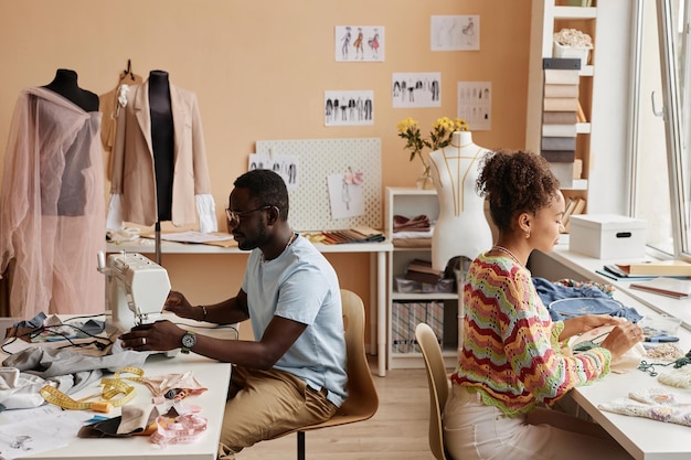 Zwei junge afroamerikanische Modedesigner arbeiten im Atelier