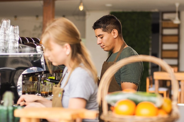 Foto zwei junge baristas bereiten in einem café getränke zu