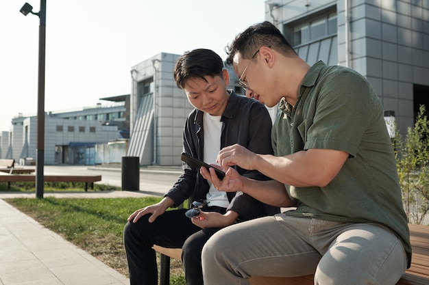 Zwei junge chinesische Angestellte schauen sich Online-Videos an