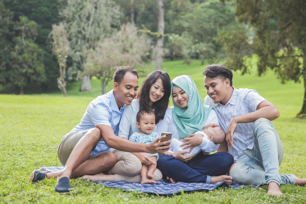 Zwei junge Familie im Park, der Handy betrachtet