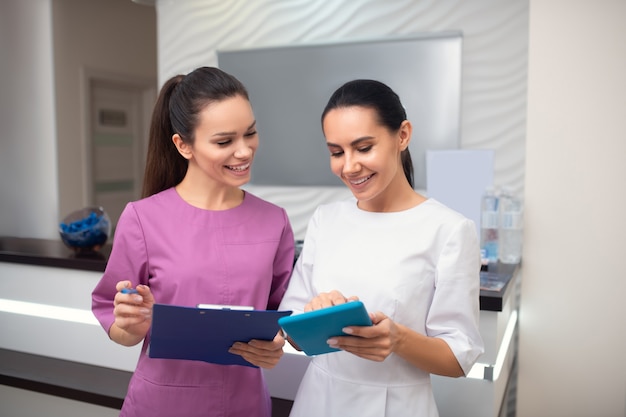 Zwei junge Frauen an der Rezeption einer Klinik