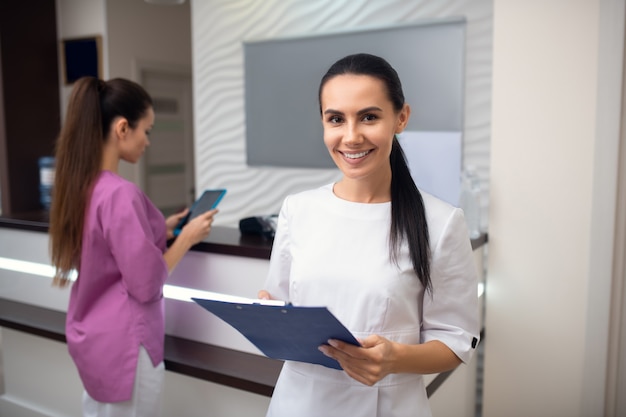 Zwei junge Frauen an der Rezeption einer Klinik