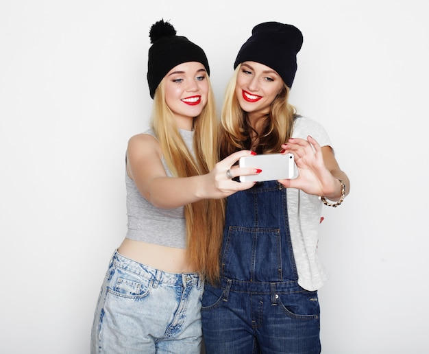 Zwei junge Frauen, die selfie mit Handy nehmen