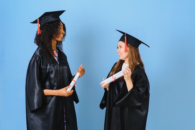 Zwei junge Frauen feiern ihren Abschluss mit Diplom