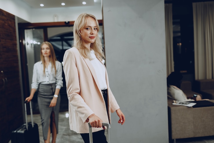 Foto zwei junge frauen in formeller kleidung betreten die hotellobby