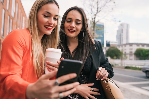 Zwei junge Freunde machen ein Selfie mit Handy.