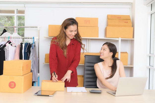 Foto zwei junge geschäftsfrauen diskutieren in ihrem home office fröhlich über online-marketing-pläne