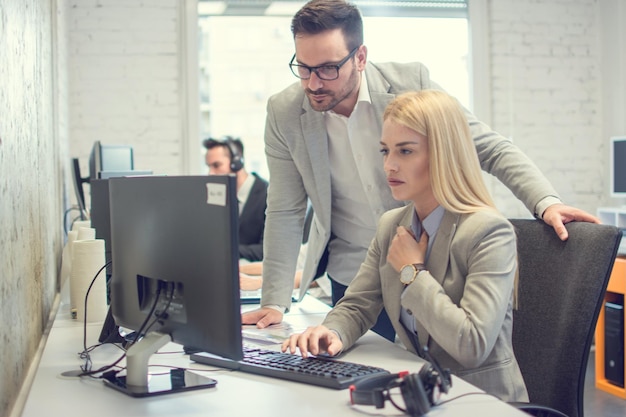 Zwei junge Geschäftskollegen arbeiten zusammen an einem Projekt am Computer