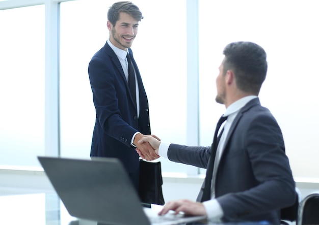Zwei junge Geschäftskollegen schütteln sich während des Treffens die Hände