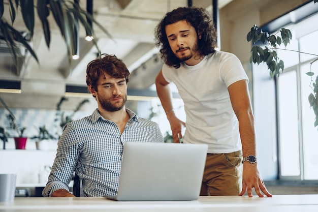 Zwei junge Geschäftsleute diskutieren einige Ideen im modernen Büro