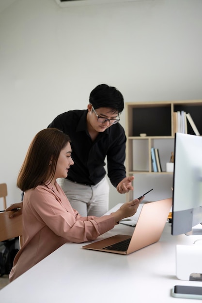 Zwei junge Geschäftsleute diskutieren Geschäftsidee im modernen Büro