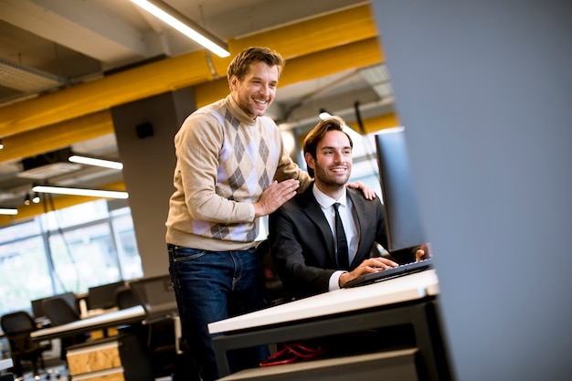 Zwei junge Geschäftsleute diskutieren im Büro am Tisch