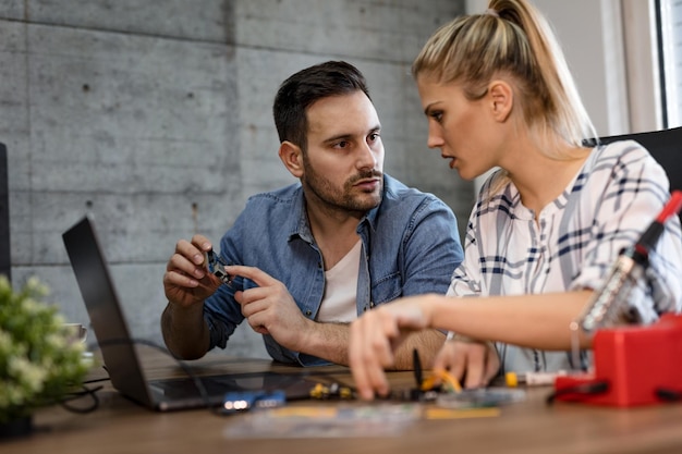 Zwei junge Geschäftspartner Techniker konzentrierten sich auf die Reparatur von elektronischen Geräten.