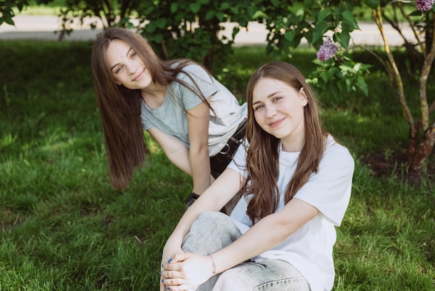 Zwei junge glückliche Teenager-Mädchen, die sich an einem Sommertag im Park amüsieren. Weibliche Freundschaft. Weicher selektiver Fokus.