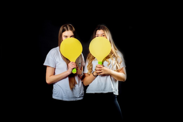 Zwei junge kaukasische junge Teenager-Mädchen, die Badminton spielen