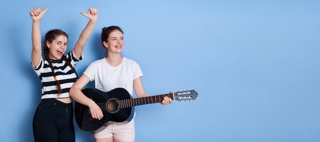 Zwei junge Mädchen mit Gitarrenspiel und singen