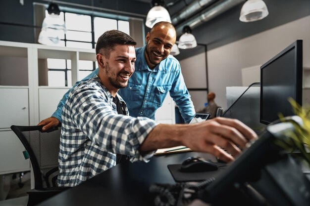 Zwei junge Männer, die gemeinsam an einem neuen Geschäftsprojekt im Büro arbeiten