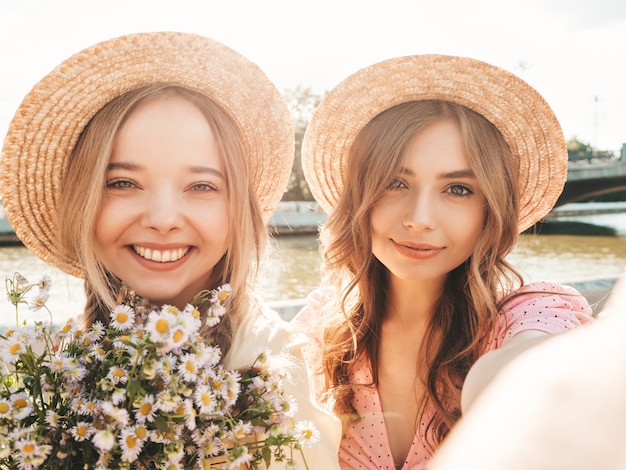 Zwei junge schöne lächelnde Hippie-Frau im trendigen Sommerkleid