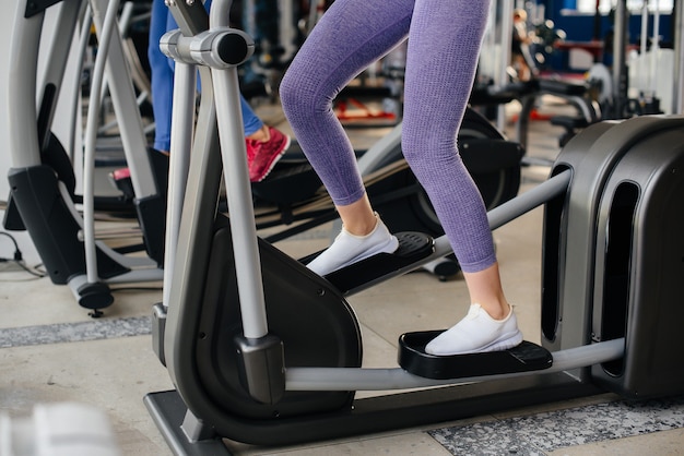 Zwei junge schöne Mädchen trainieren im Fitnessstudio mit Masken während der Pandemie