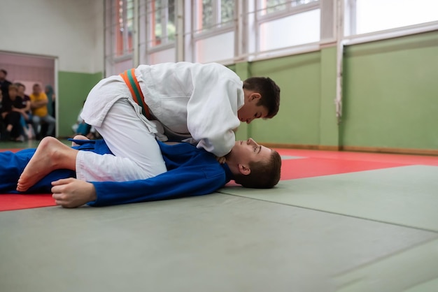 Zwei junge Sportler zeigen vor den Trainern ihr Judo-Können