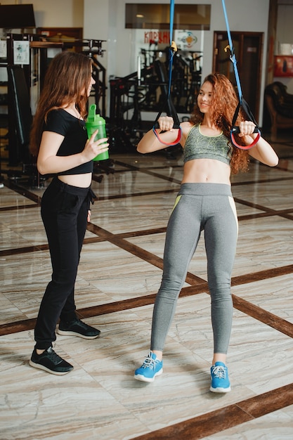 Zwei junge und athletische Mädchen treiben Sport im Fitnessstudio