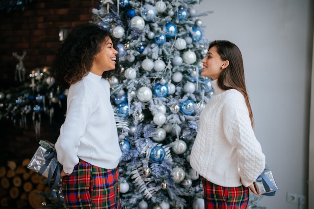 Zwei junge und glückliche beste Freunde und Mitbewohner tauschen Geschenke aus