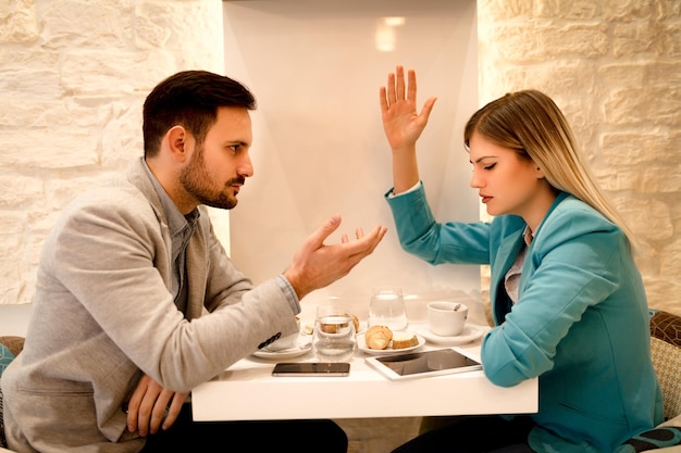 Foto zwei junge wütende geschäftsleute streiten sich im café.