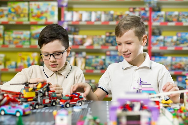 Zwei Jungen spielen zusammen mit farbigen Plastikklötzen in der Spielcenterschule