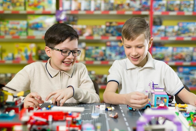 Zwei Jungen spielen zusammen mit farbigen Plastikklötzen in der Spielcenterschule