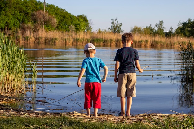 Zwei Jungen stehen am Fluss Das Konzept der Freundschaft und Brüderlichkeit Sommerurlaub