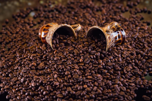 Zwei Kaffeetassen voller gerösteter Kaffeebohnen. Schöner Kaffeehintergrund.