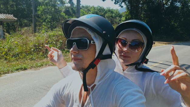 Zwei kaukasische touristische Frau Mann fahren auf rotem Roller Machen Sie es selfie Liebespaar auf dem Motorrad