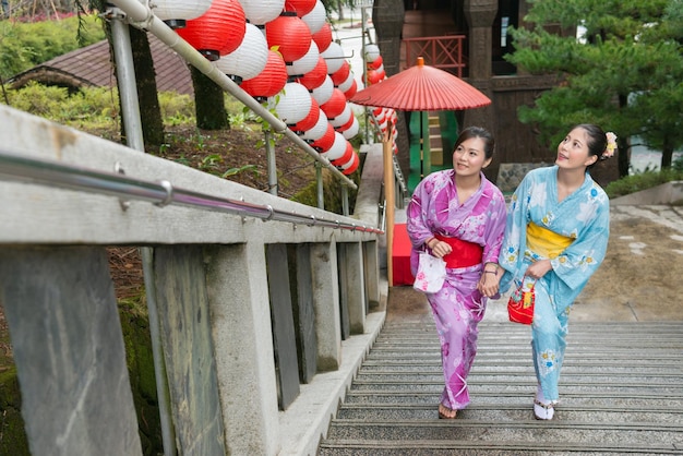 zwei Kimonos Asiatische japanische Mädchen, die auf der Treppe spazieren gehen, genießen den Urlaub