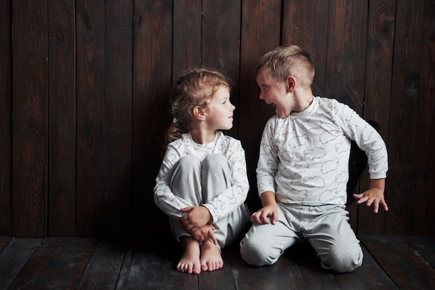 Zwei Kinder, Bruder und Schwester im Pyjama, spielen zusammen