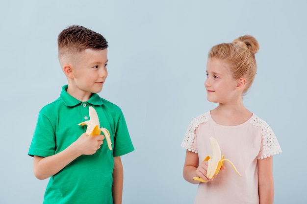 Zwei Kinder essen frische Bananen