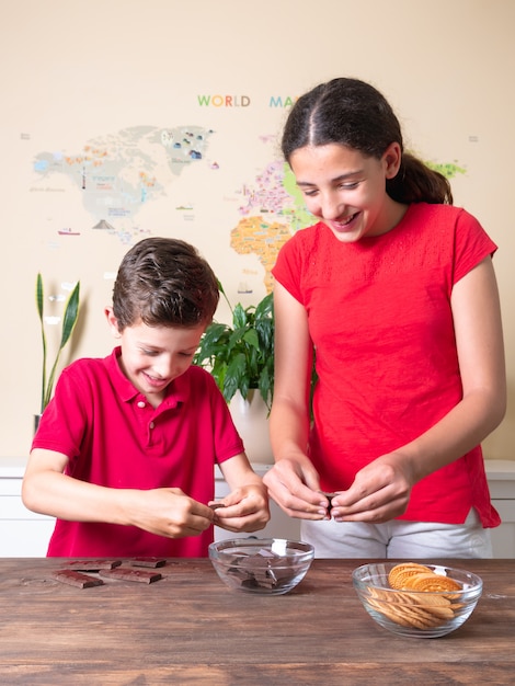 Zwei Kinder in der Küche bereiten Zutaten vor, um einen Kuchen zu backen