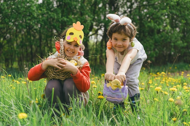 Zwei Kinder suchen in einem Frühlingsgarten nach Ostereiern