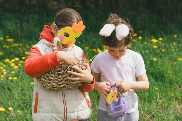 Zwei Kinder suchen in einem Frühlingsgarten nach Ostereiern.