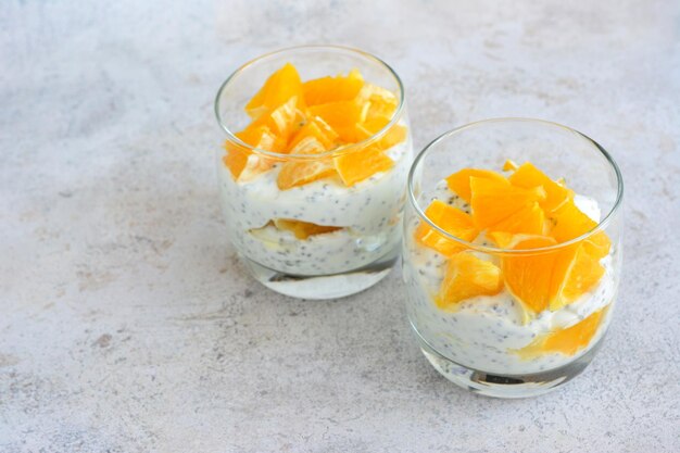 zwei kleine Gläser Chia-Pudding mit Orangenstücken