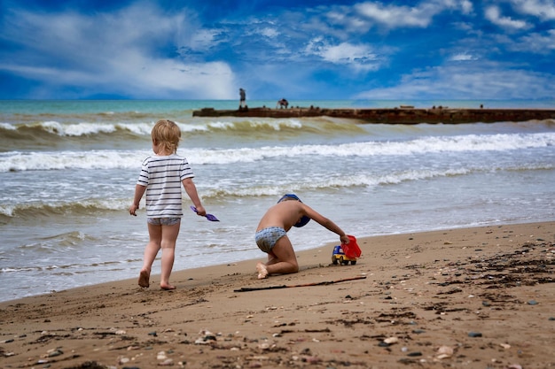 Zwei kleine Jungen spielen am Strand