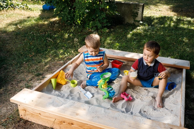 Zwei kleine Jungs spielen im Sandkasten