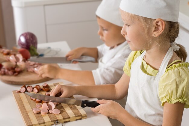 Zwei kleine Kinder in Kochuniformen