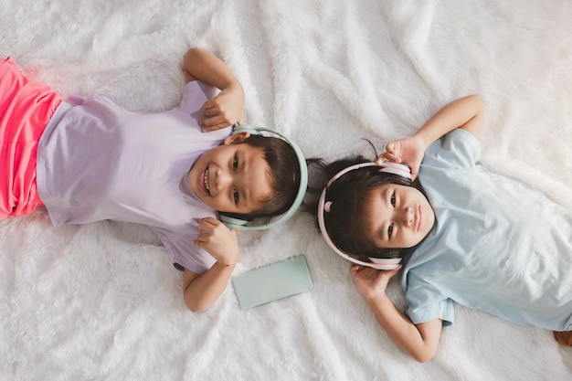 Zwei kleine Kinder schlafen glücklich und hören Musik mit Kopfhörern.