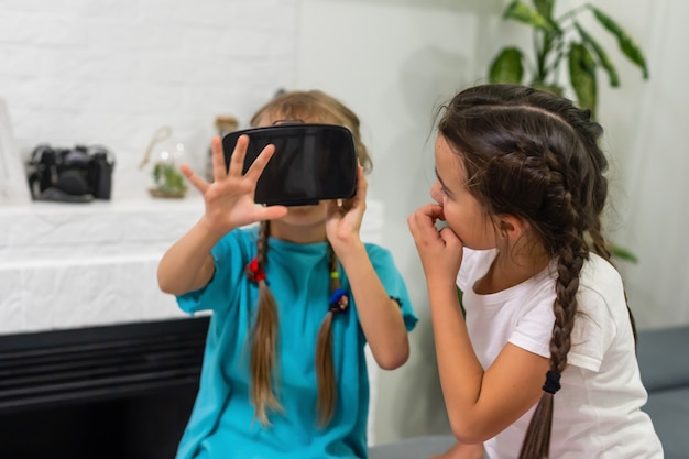 zwei kleine Mädchen, die Videospiele Virtual-Reality-Brille spielen