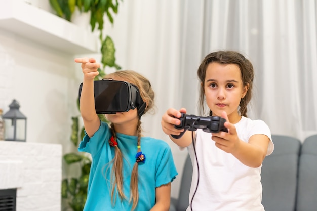 zwei kleine Mädchen, die Videospiele Virtual-Reality-Brille spielen